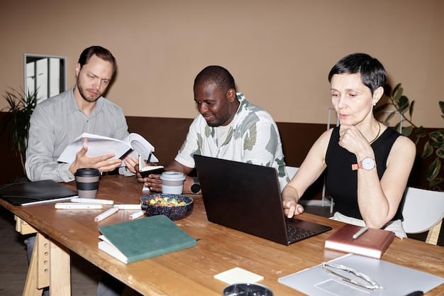 A diverse group of people gathered around a table, looking at laptops and documents, symbolizing a crisis communication team working together effectively.